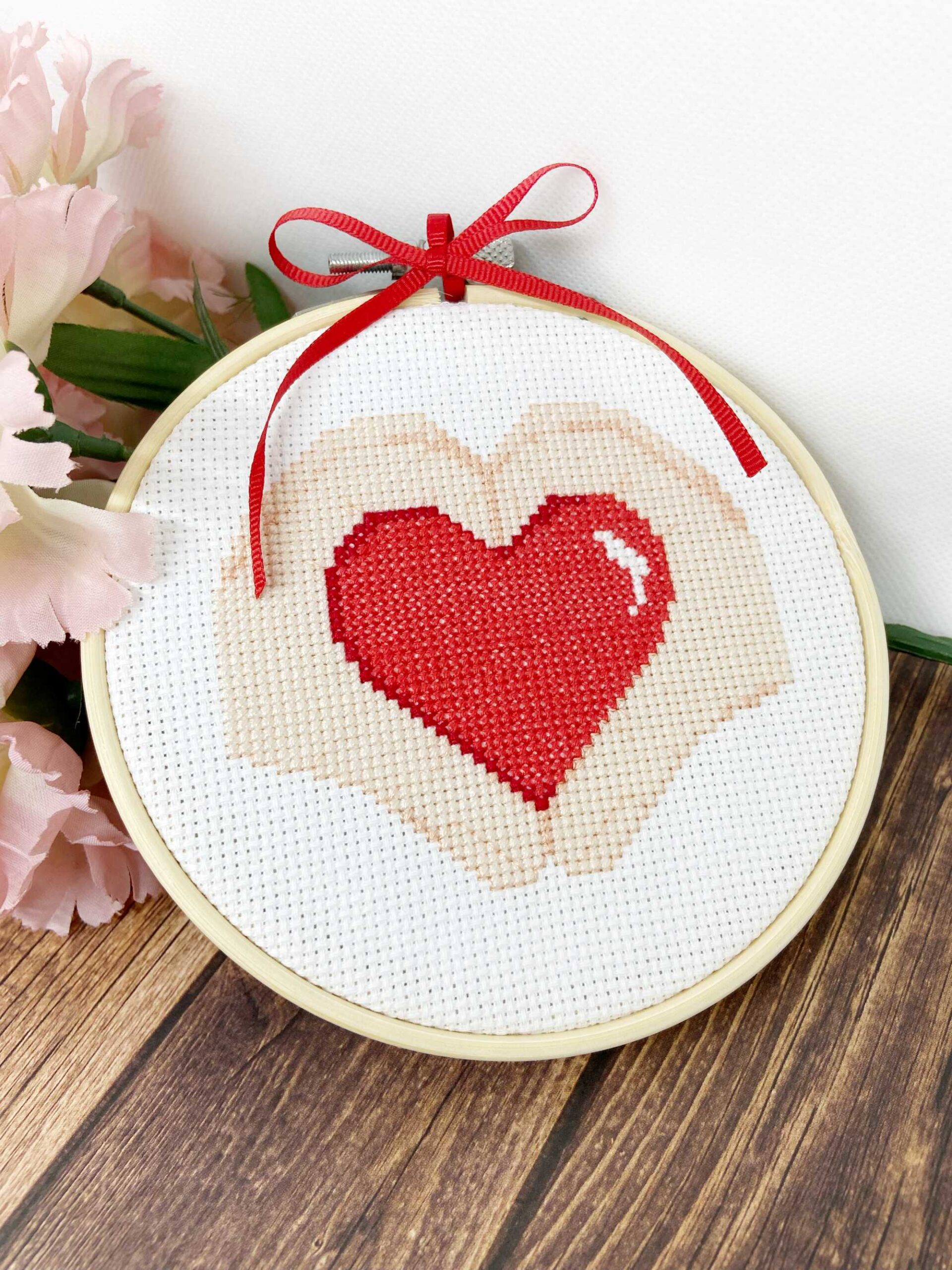 Heart Hands cross-stitch pattern by Chrissy Habblett, shown finished in standard bamboo embroidery hoop