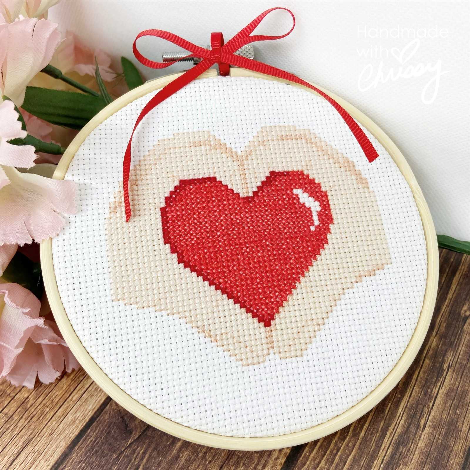 Heart Hands cross-stitch pattern by Chrissy Habblett, shown finished in standard bamboo embroidery hoop