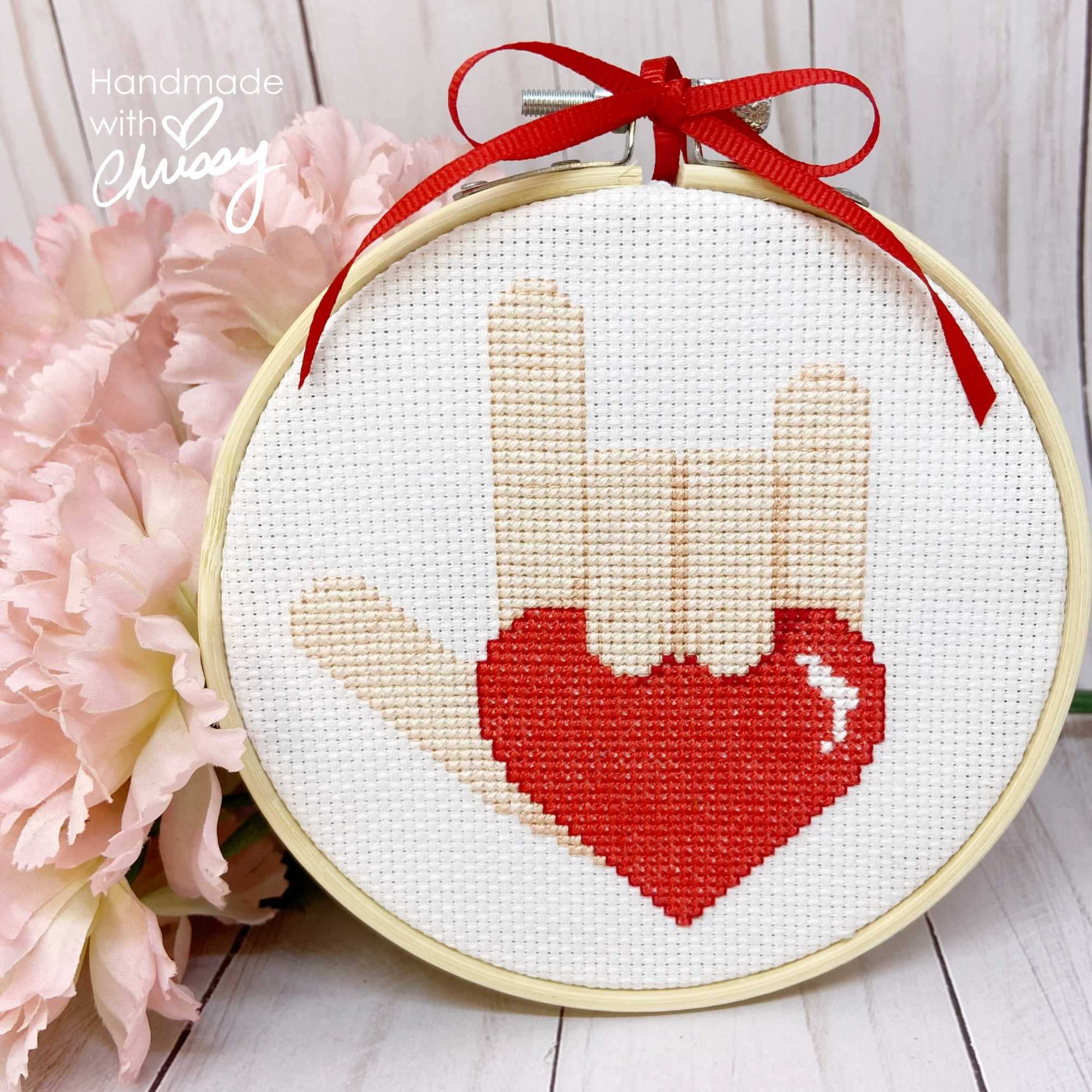 Sign of Love cross-stitch pattern by Chrissy Habblett, shown finished in standard bamboo embroidery hoop